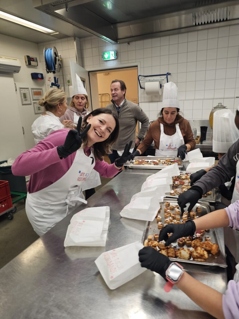 Kirberg Mitarbeiter und weitere Helfer, die ehrenamtlich eine Plätzchen-Back-Aktion in der Küche der Flora Köln unterstützen.