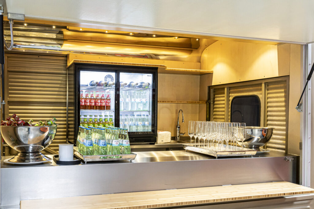 Innenansicht des Café Citron Citroën HY mit Getränkekühlschrank, Gläsern und Catering-Setup für Business-Events.