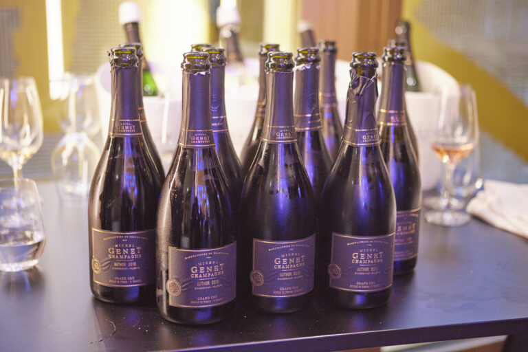 Flaschen französischen Genet Champagners auf einem festlich gedeckten Tisch als Teil eines Champagnerdinners mit Fingerfood, Austern und französischem Flair.